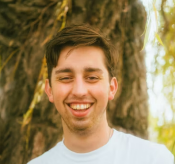 a smiling man in a white T-shirt